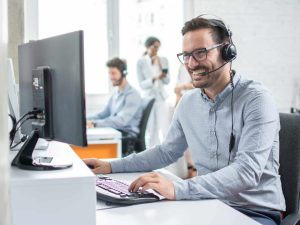Smiling customer support operator with hands-free headset workin